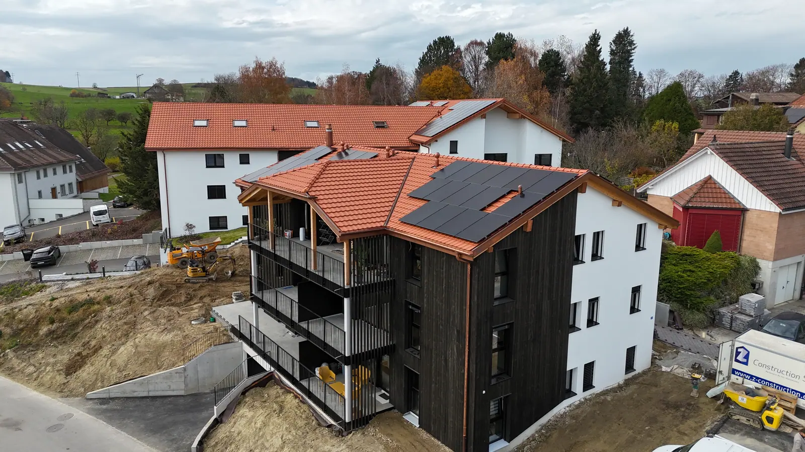Immeuble à façade bois en phase de finitions, abords en cours de terrassement