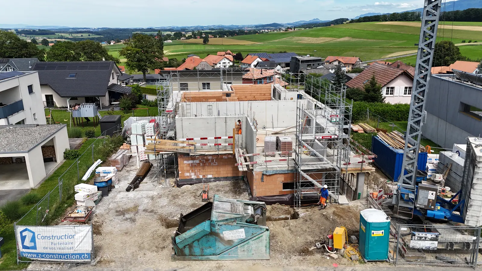 Chantier d’une villa en maçonnerie, grue et échafaudages, Villargiroud